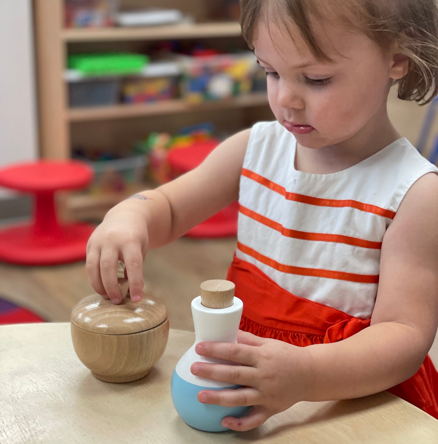 young girl playing with wooden toys from wicking vicar
