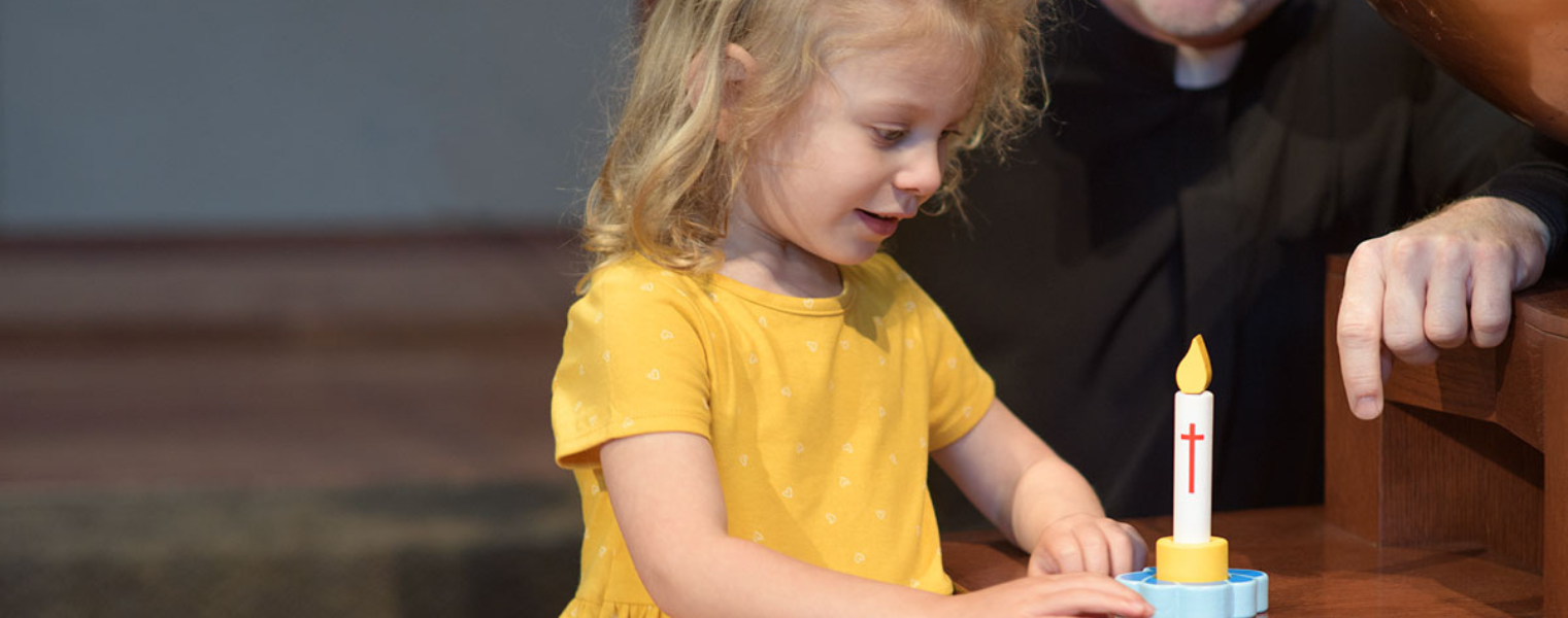 A young girl playing with a wicking vicar toy candle.