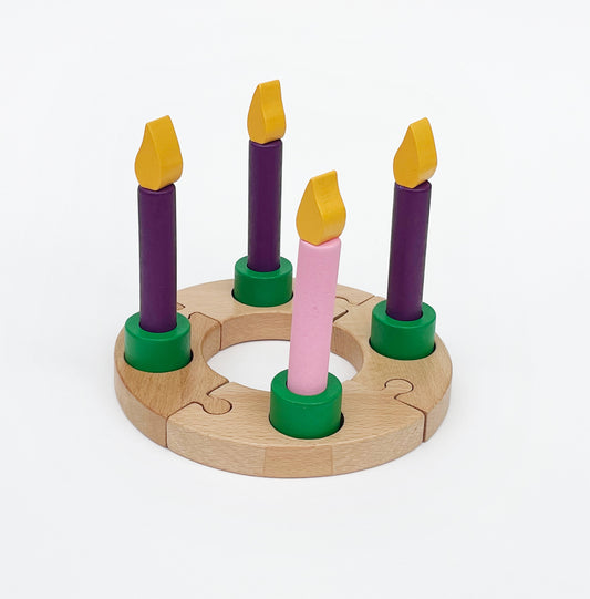 A wooden Advent wreath with 16 pieces, featuring three purple and one pink candle holders, arranged to form a circle.