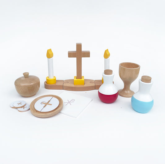 A children's mass set including a buildable altar piece with a cross and candles, a wine cruet, a holy water cruet, a chalice, a chalice pall, a paten with a priest host, and a ciborium with six hosts, all made of wood and designed for pretend play.