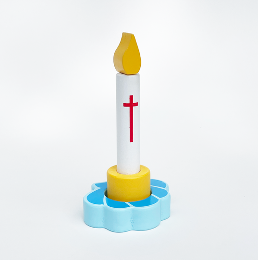 A wooden baptism candle toy with a white candle shaft, a red cross, a yellow wick, and a blue base resembling a flower. The toy is designed for children.