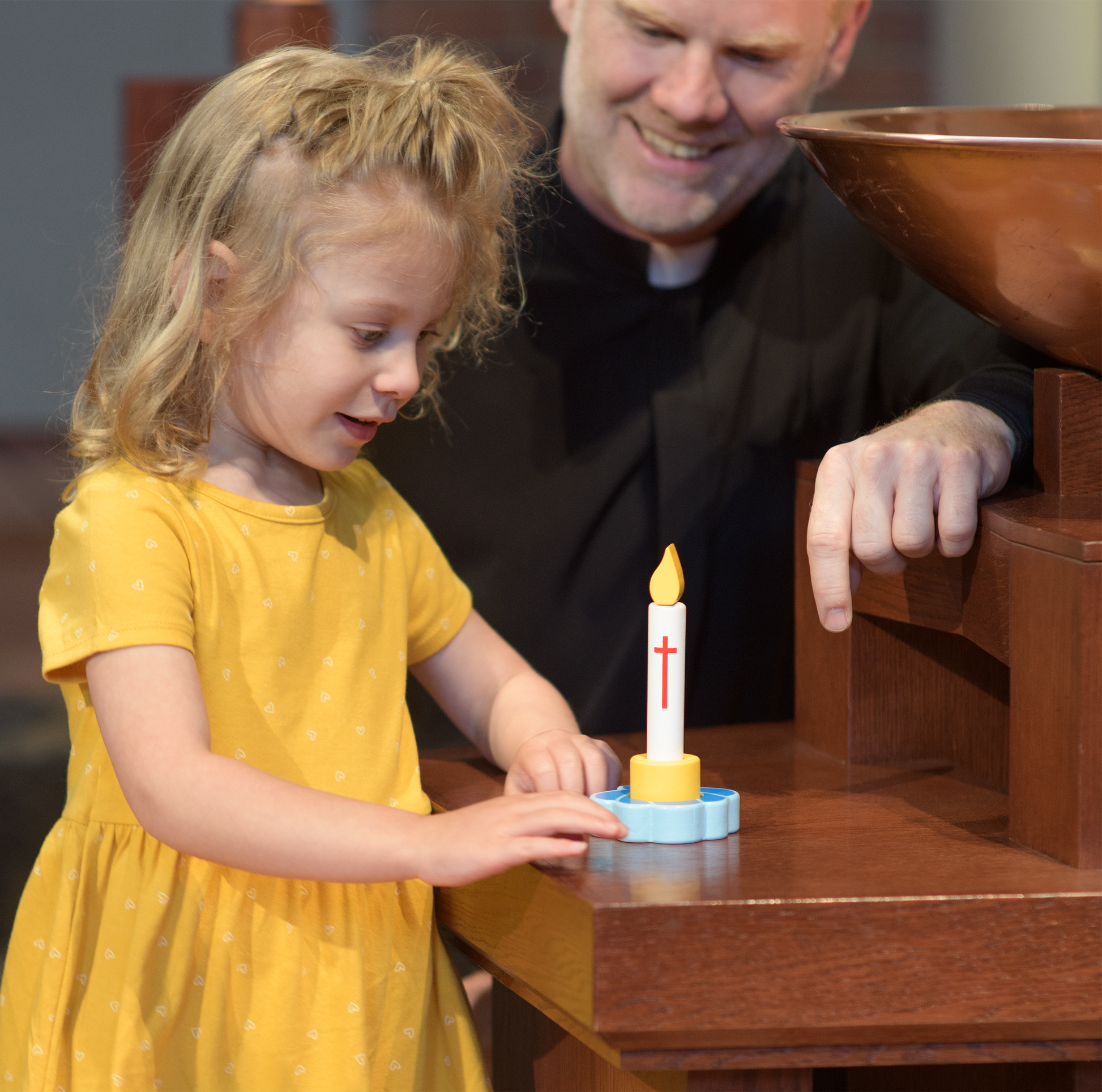A child playing with a Wicking Vicar wooden candle.