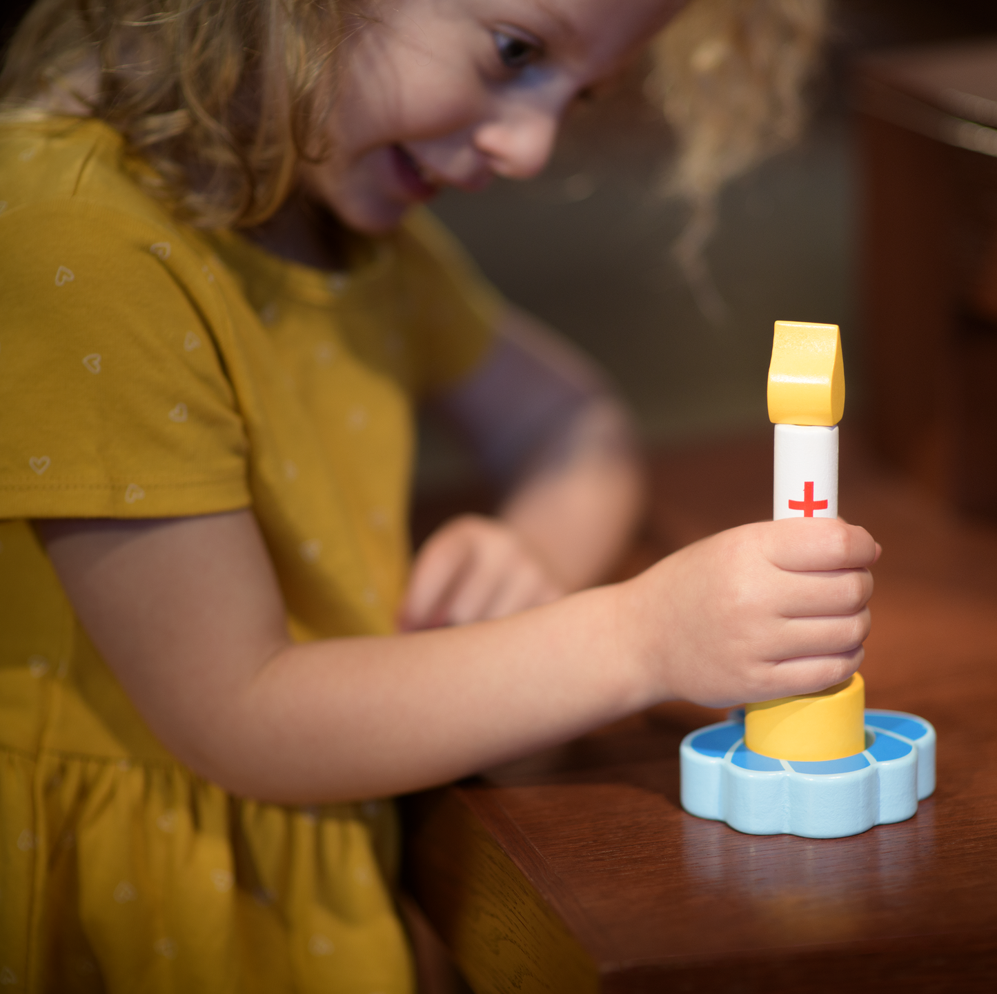 child holding a wooden baptism candle